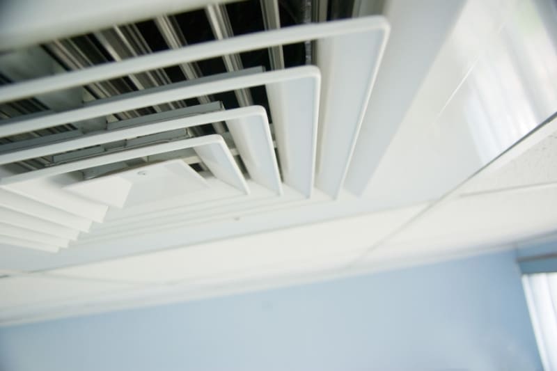 HVAC System Problems That Affect Employee Productivity and Health. Air condition vent in office ceiling close up.